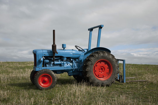 Fototapeta A tractor in a field