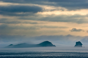 Naklejka na ściany i meble Mist covers the seaside at dawn.