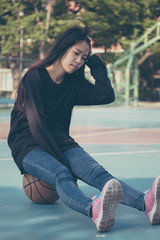 Fototapeta na wymiar asia thai teenager Women black T-Shirt relax and smile in Basketball court