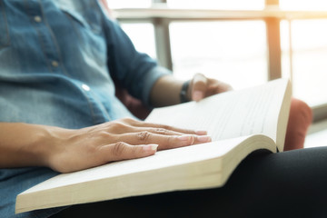 Reading a book.Beautiful female legs sitting on the sofa reading a book.Morning with a book and cop of coffee.Retro filter effect,soft focus,selective focus)
