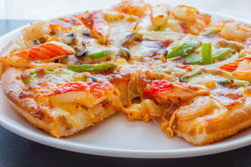 Seafood Italian Pizza slice in paper box.