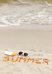 Fototapeta na wymiar Inscription summer, sunglasses and sun lotion on sand at beach, sun protection, summer time