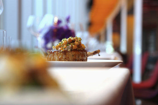 A lamb cutlet with carrot salsa on a plate