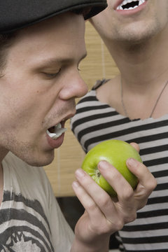 Two Young Men Wearing Plastic Vampire Teeth