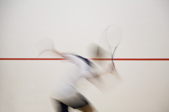 A man playing squash, blurred motion