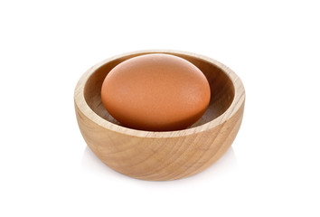 raw egg in wooden bowl on white background