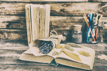 Bouquet of a dry lavender and old books on a wooden background. Vintage composition. Vintage and retro tone