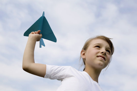 A young girl holding a model airplane