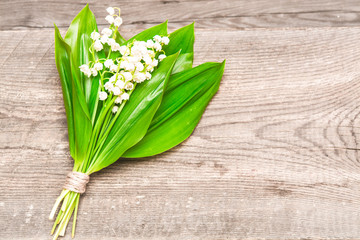 Bouquet of lilies of the valley on the wooden background. Spring