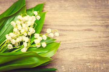 Bouquet of lilies of the valley on the wooden background. Spring