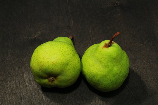 fresh pears in black wooden background