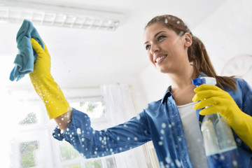 Smiling wife washed the window with a cloth