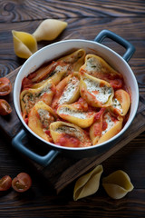 Baked conchiglioni with cottage cheese stuffing, selective focus