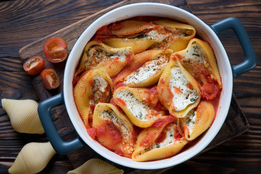 Top view of conchiglioni with cottage cheese in a baking dish