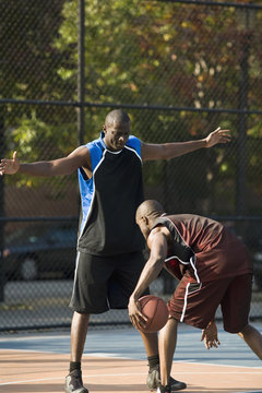 A basketball player guarding another player