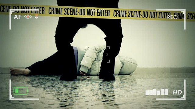 A Crime Scene Investigator picking a bullet near the dead body of a woman. Do-not-enter tape surrounding the area. Seen through the viewfinder of a recording camera.