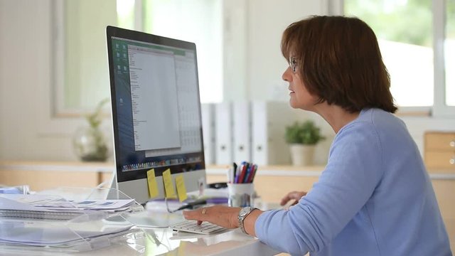 Senior woman in office working on desktop