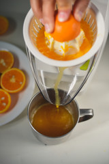 Hand holding orange fruit and making drink of fresh