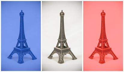 Fototapeta na wymiar Three multicolored Eiffel Tower models on french flag