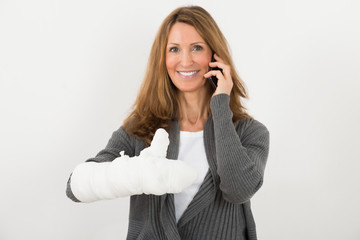 Woman With Broken Hand Talking On Mobile Phone