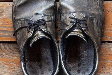 the old genuine leather shoes on a wooden background