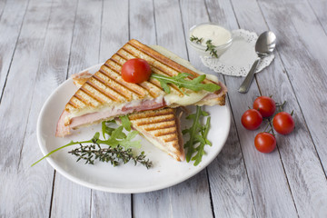 Sandwich with ham and tomatoes on wood background