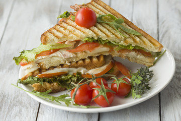Sandwich with ham and tomatoes on wood background