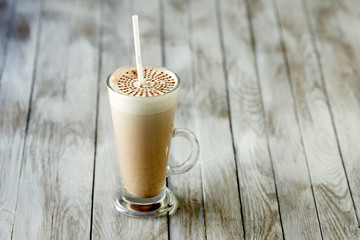 Chocolate drink in a glass on wooden background