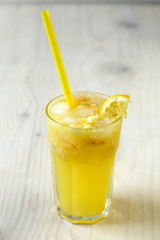 Lemonade in glass with ice and lemon in wood background