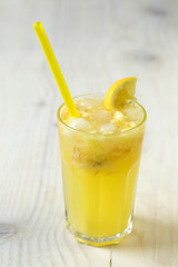 Lemonade in glass with ice and lemon in wood background