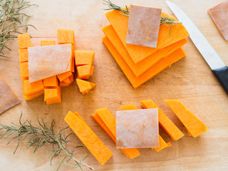 Cutting butternut squash on wooden chopping board. Top view