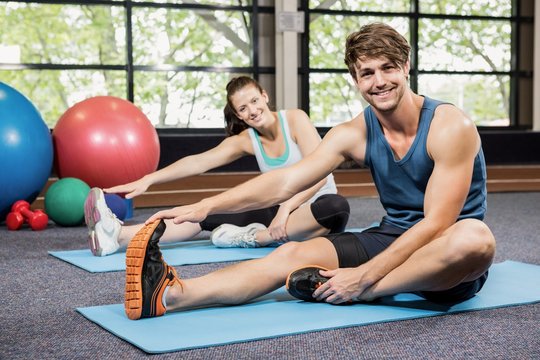 Portrait of man and woman performing fitness exercise