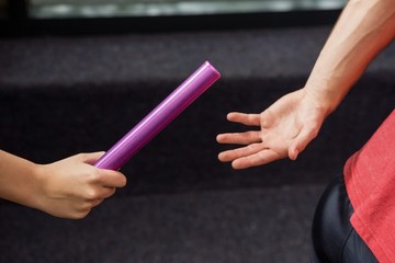 Athlete passing a baton to the partner