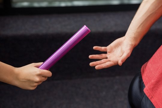 Athlete passing a baton to the partner