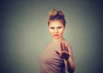 annoyed angry woman with bad attitude giving talk to hand gesture