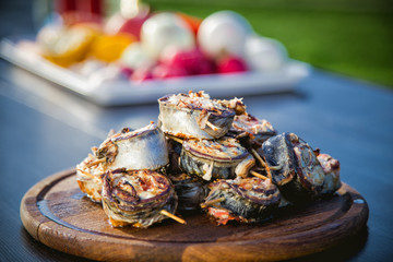 cooking rolls of mackerel on the grill, eating