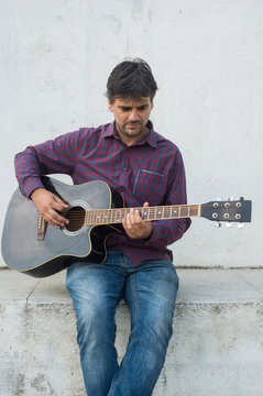 Sexy mature man playing the guitar