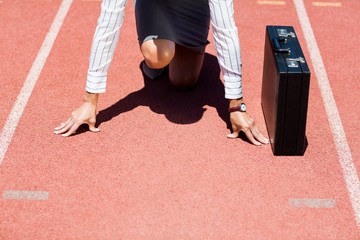 Businesswoman with briefcase in ready to run position