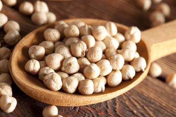 Chickpeas in spoon on wooden table