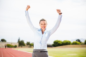 Fototapeta na wymiar Excited businesswoman standing on the running track