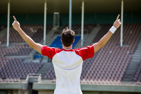 Excited football player standing in stadium
