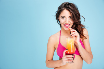 Portrait of a pretty young brunette girl drinking cocktail