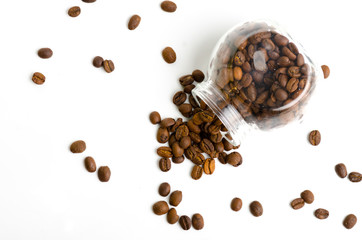 Jar with coffee beans spilling out on white