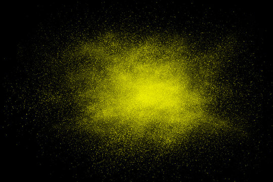 Yellow abstract powder explosion on a black background