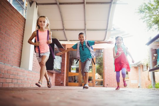 Three kids running in the playground