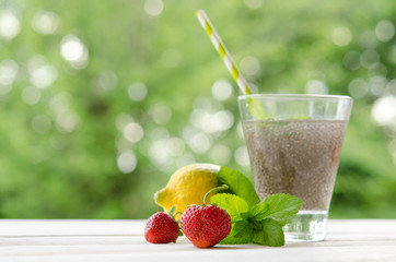 Chia seeds drink with water in transparent glass with lemon, min