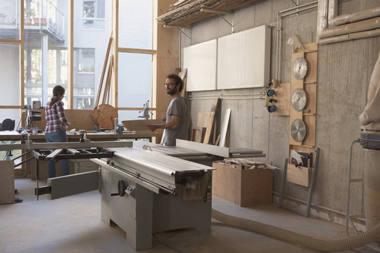 Male and female carpenters working in workshop