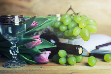 wooden table with wine bottle book and grape