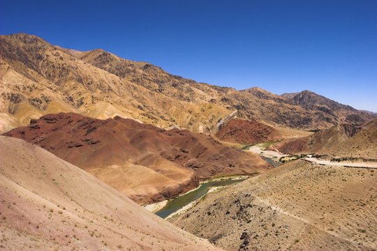 Hari Rud river flows through fertile valley at base of red rock mountains, between Jam and Chist-I-Sharif, Ghor (Ghowr province), Afghanistan