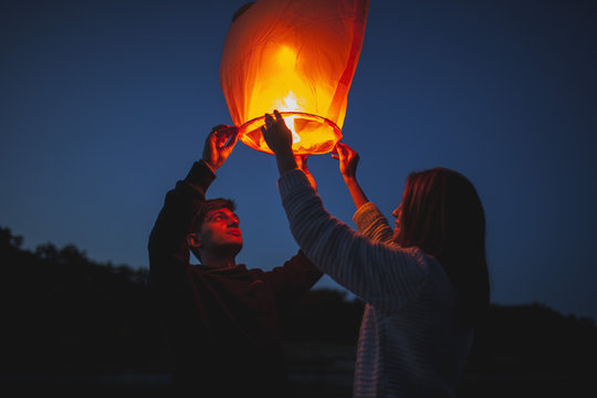 Low angle view of hikers releasing paper lanterns